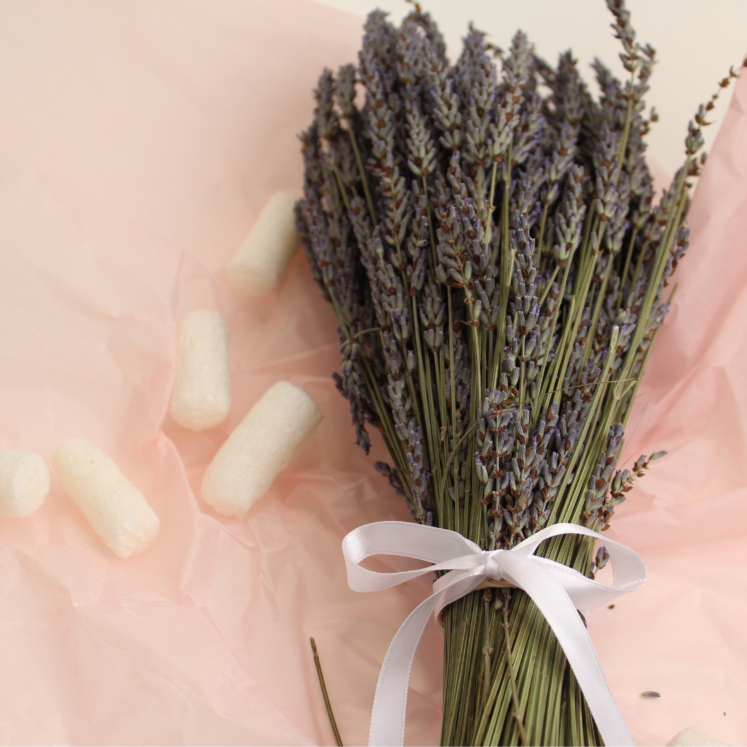 10 Great Gifts Ideas For Someone Who Has Everything featured image showing a dried lavender bouquet tied with a white ribbon, resting on a pink background. The text "Holiday Gift Guide" is superimposed over the image
