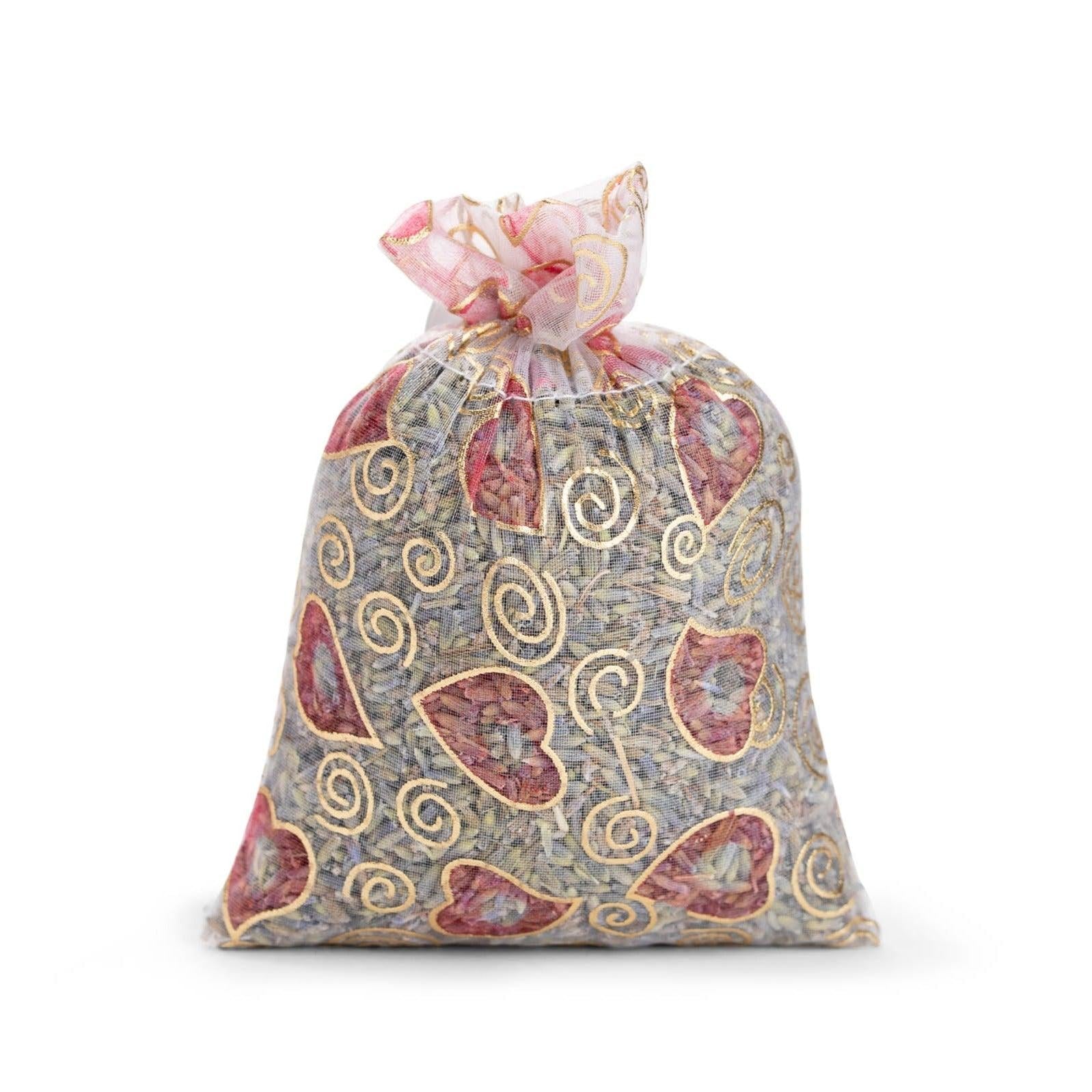 A transparant organza sachet for drawers with gold hearts and swirls, filled with lavender on white background