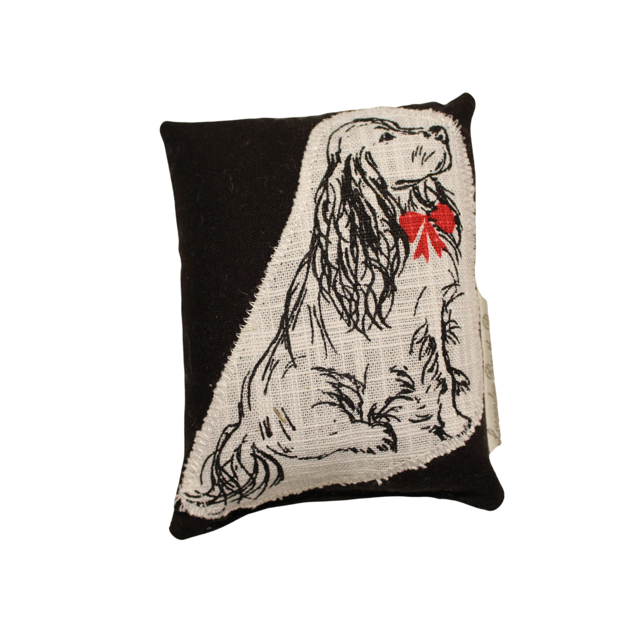 A blackhome fragrance sachet
pillow with an Applique of a long-haired dog wearing a red bow