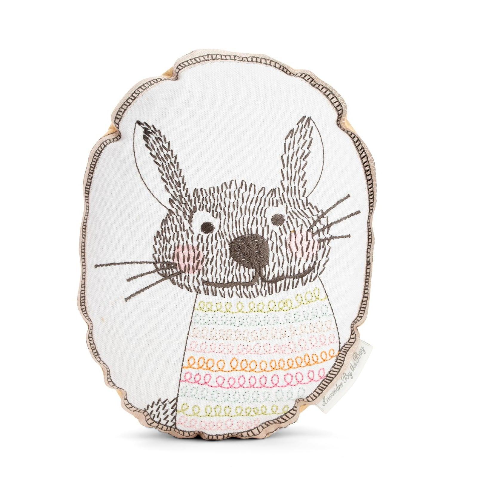 A decorative home fragrance sachet featuring a hand-stitched rabbit with a playful expression and a colorful sweater.