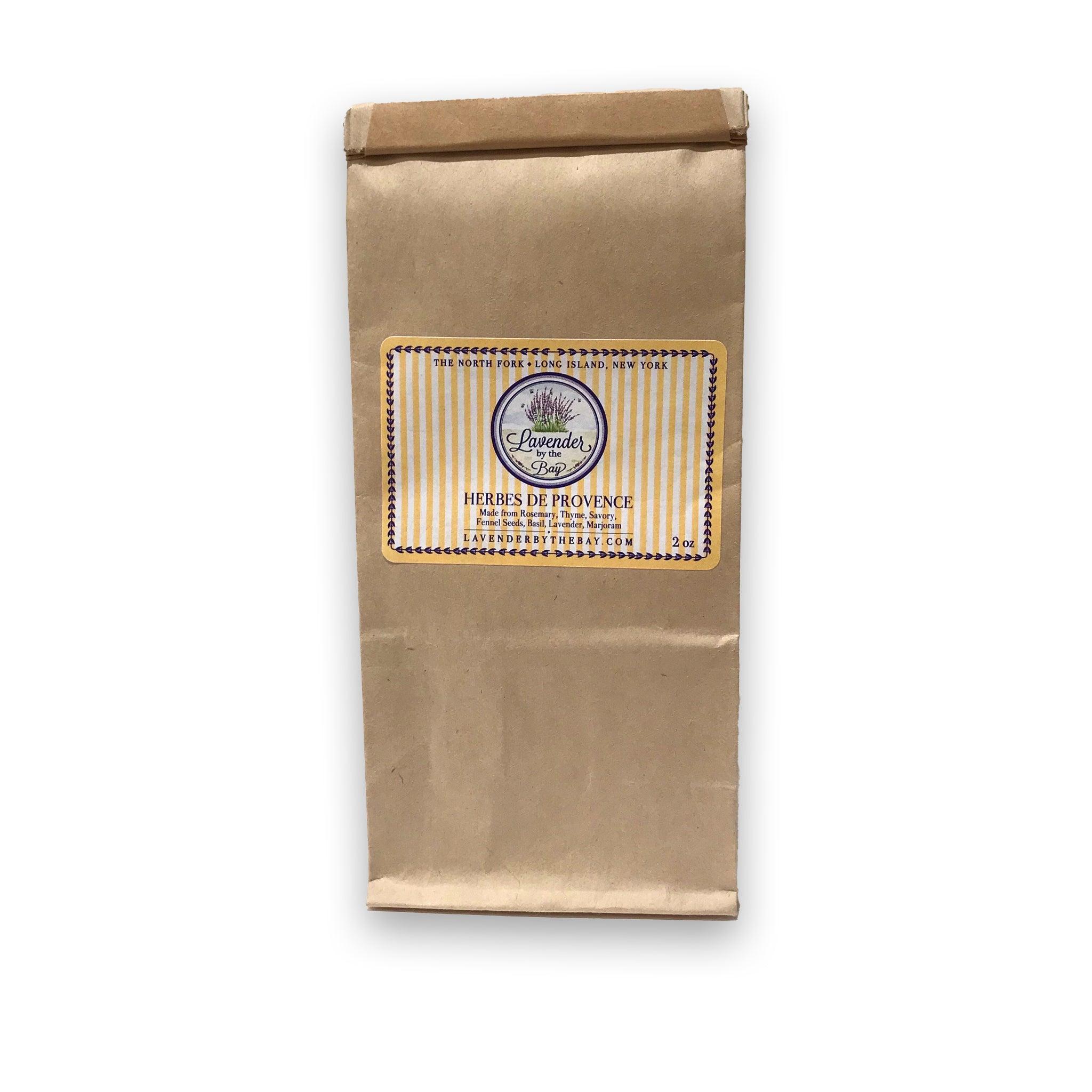 A brown paper bag with a label for "Herbes de Provence," a blend of Fragrant Herbes. The label includes the brand name "Lavender by the Bay" and LBTB website address
