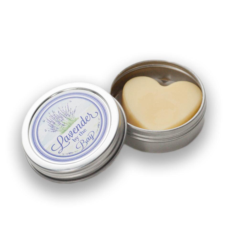 heart-shaped piece of Lavender Beeswax Lotion Bar packaged in a round tin