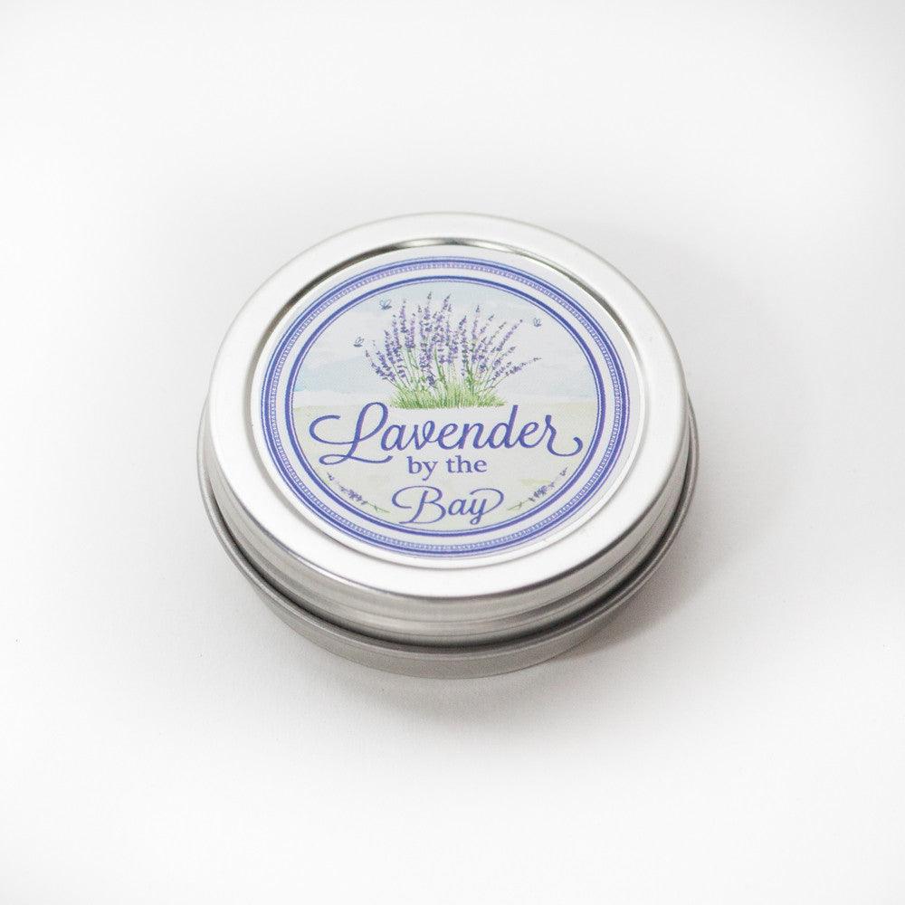 The closed round tin of the lotion with beeswax with the logo of Lavender By the Bay on it