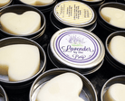 Multiple lotion bars with beeswax tins open and one closed