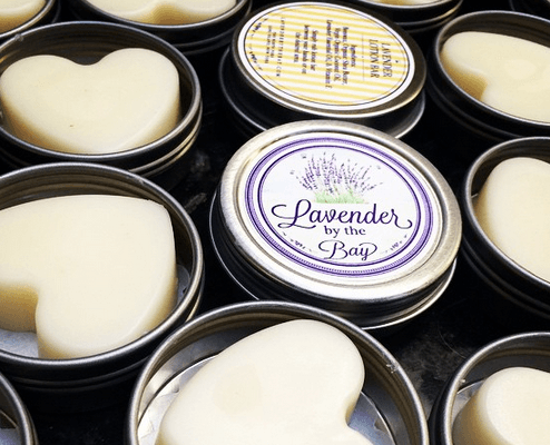 Multiple lotion bars with beeswax tins open and one closed
