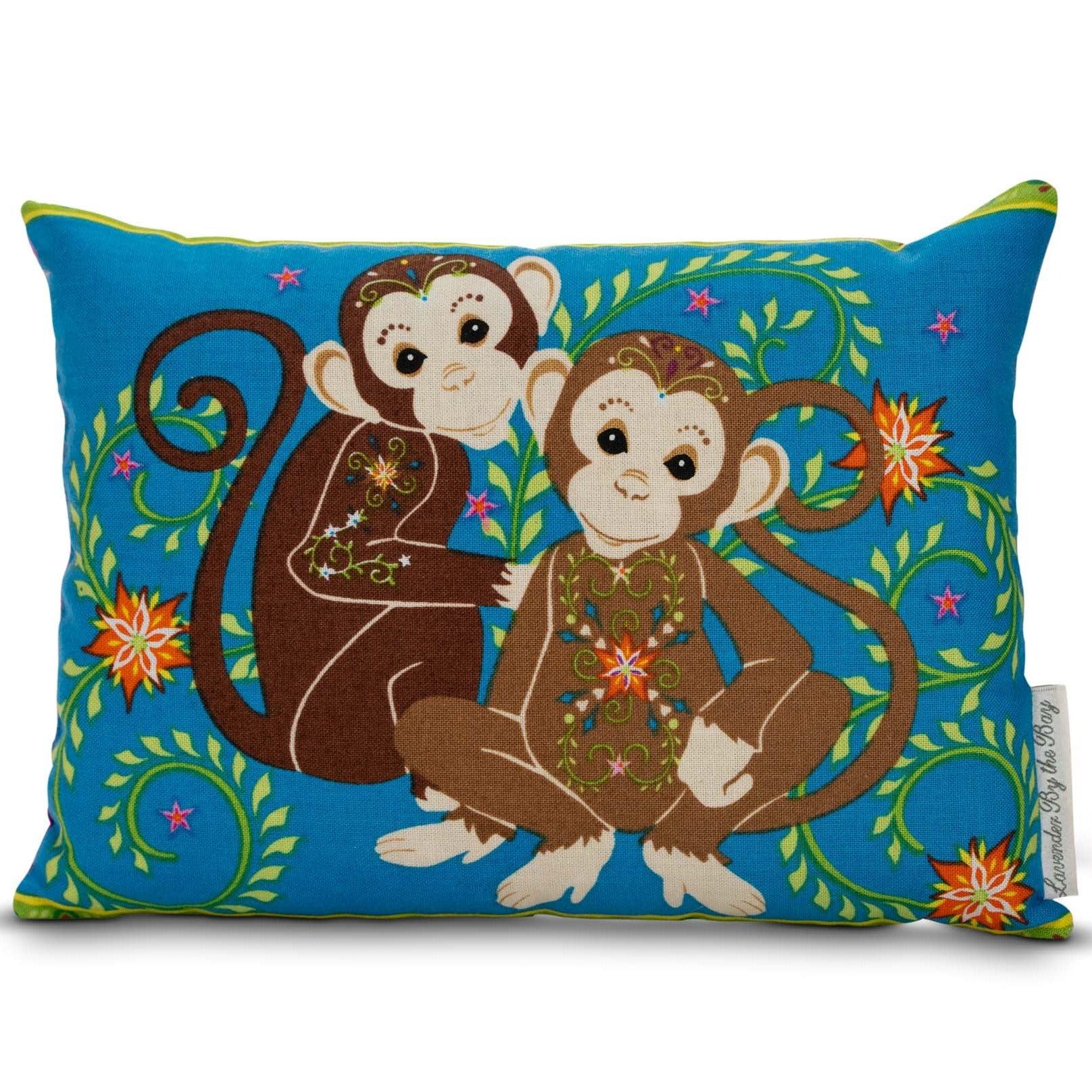 2 Monkeys one black and one brown sitting next to each other featuring on a blue pillow sachet