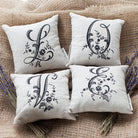4 monogrammed pillows L Q V and E letters laying on burlap sack with 2 lavender bouquet from each side