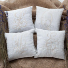 4 white Monogrammed pillows each pillow features a different embroidered letters L Q V E in a similar style The pillows are arranged on a burlap background with lavenders flowers bouquet on each side