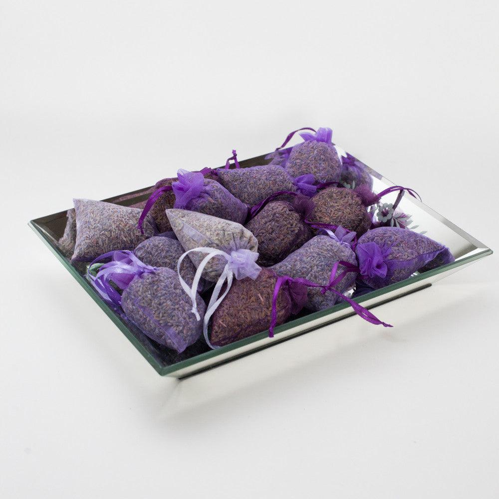 A rectangular silver tray filled with 15 purple sachet packets filled with lavender, tied with purple ribbons.