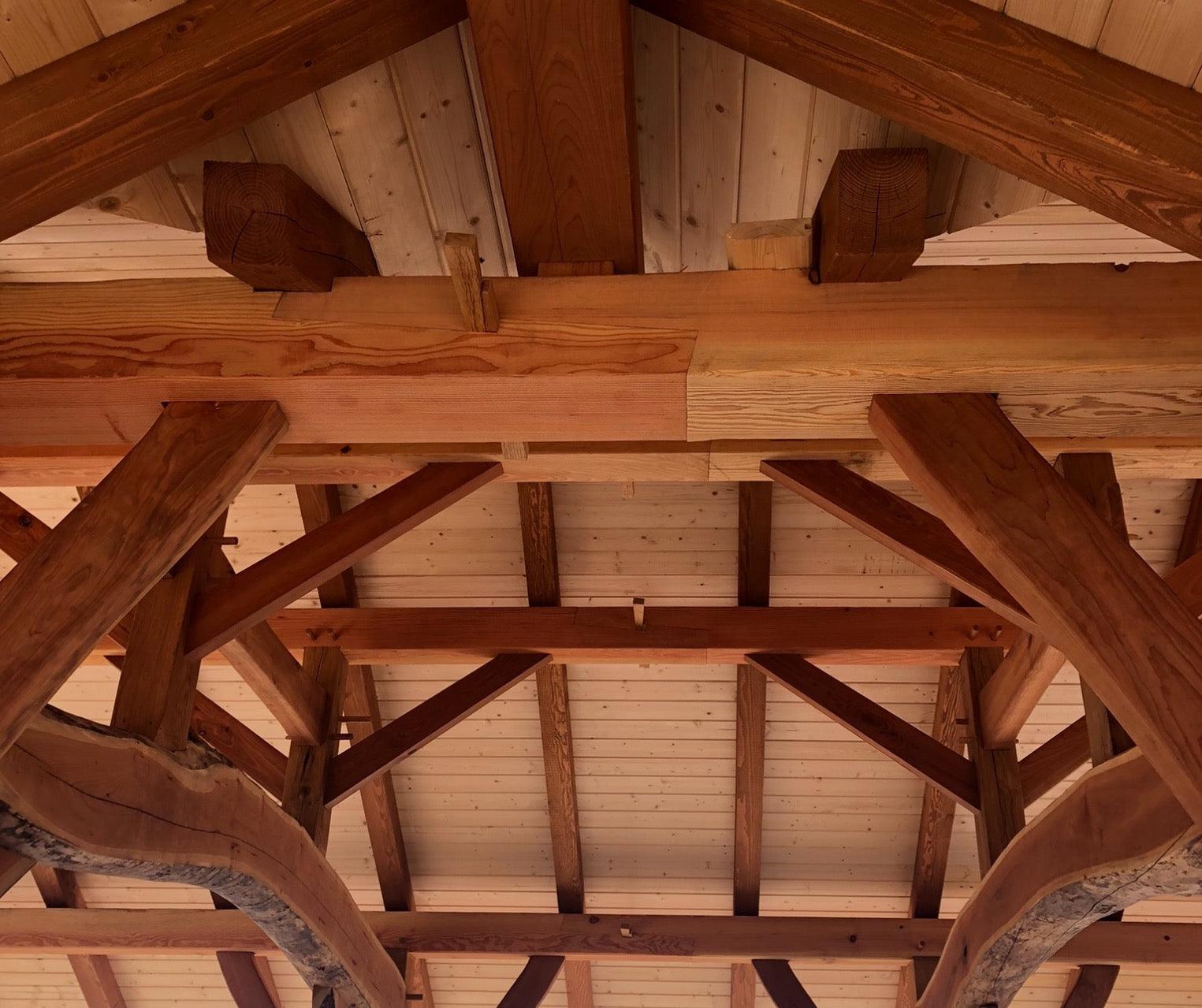 timber frame Pavilions: East Marion and Calverton featured image of a close-up of a timber-framed ceiling, showcasing the intricate joinery and the warm, natural tones of the wood